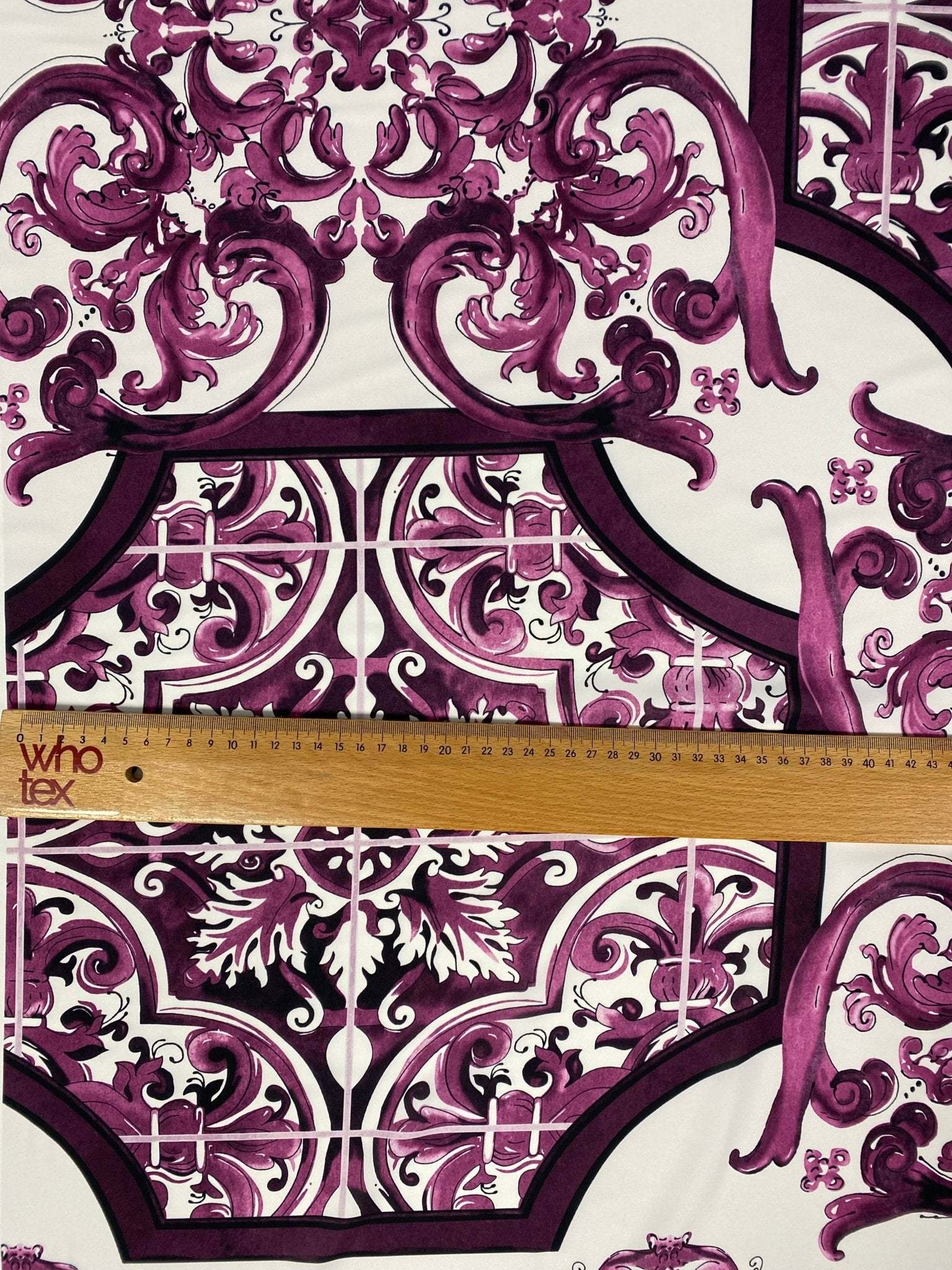 Baroque style purple ornamental print fabric with intricate design and ruler for scale
