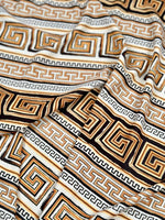 Beige brown silky crepe fabric with geometric and Greek key patterns, smooth and draping textile ideal for garments