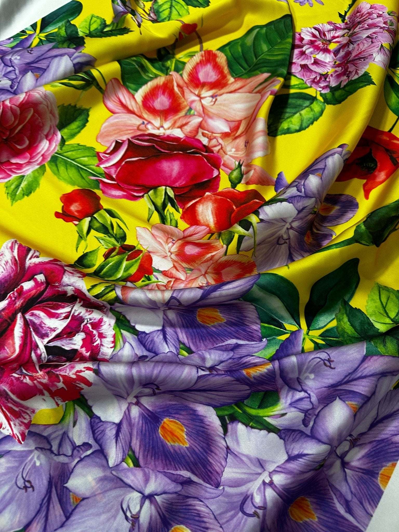 Bright yellow fabric with large rose and floral pattern in vibrant colors for fashion and home decor