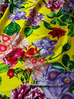 Bright yellow fabric with large vibrant rose and floral print for fashion and home decor