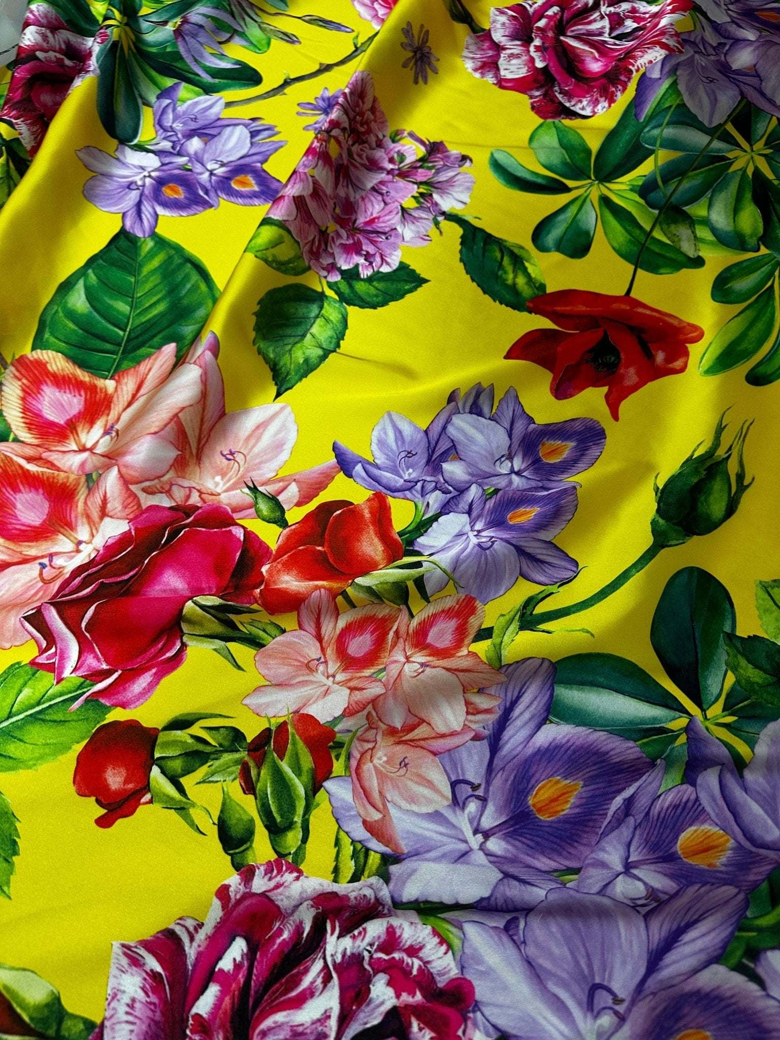 Bright yellow fabric with large vibrant rose and floral print for fashion and home decor