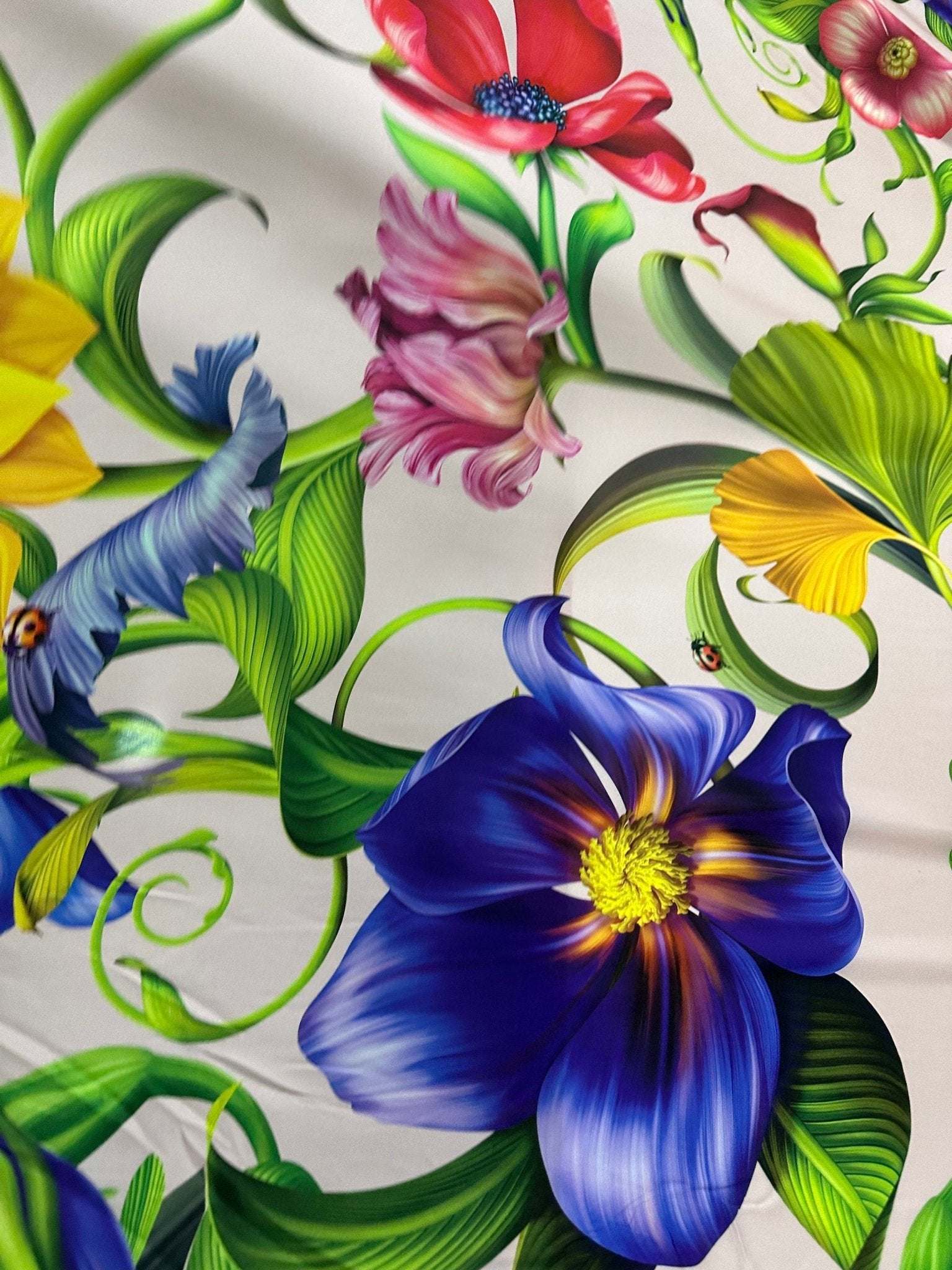 Tropical floral fabric with vibrant multicolored flowers and green leaves on a white background
