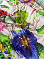 Tropical floral fabric with vibrant multicolor flower and leaf pattern on light background, ideal for sewing and crafts