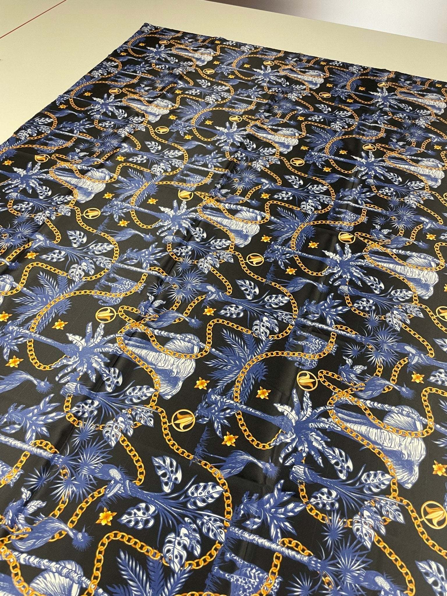 Black and blue tropical fabric with gold chain pattern on 150cm wide material