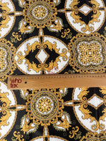 Black and gold medallion fabric with ornate Baroque design and ruler for scale