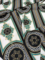 Greek key pattern fabric with black, white, green, and gold decorative design for upholstery and drapery.