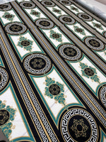 Greek Key Pattern Fabric with black, white, and gold intricate geometric and floral designs on a wide fabric roll