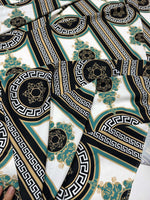 Close-up of Greek Key Pattern Fabric with black, white, gold, and teal geometric and ornamental designs