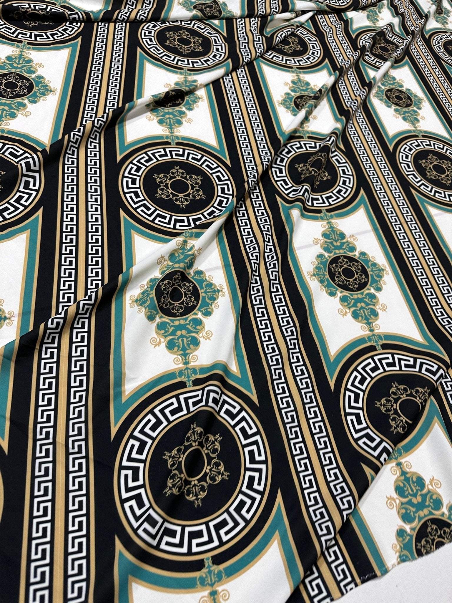 Greek Key Pattern Fabric with black, teal, and gold geometric and ornamental designs on white background, ideal for upholstery and drapery projects