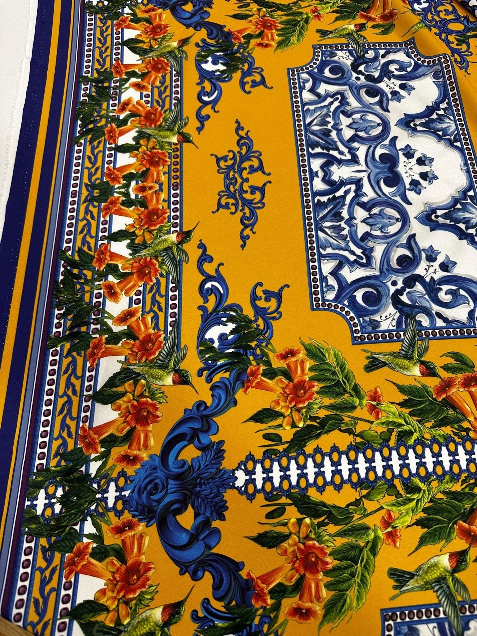 Elegant mustard yellow Baroque floral fabric featuring intricate blue and orange floral patterns for upholstery and garments