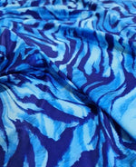 Close-up of durable blue zebra print fabric with vibrant stripes for sewing projects
