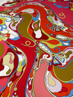 Colorful abstract swirl pattern fabric with vibrant red, pink, orange, blue, and olive green hues, ideal for crafting and sewing projects