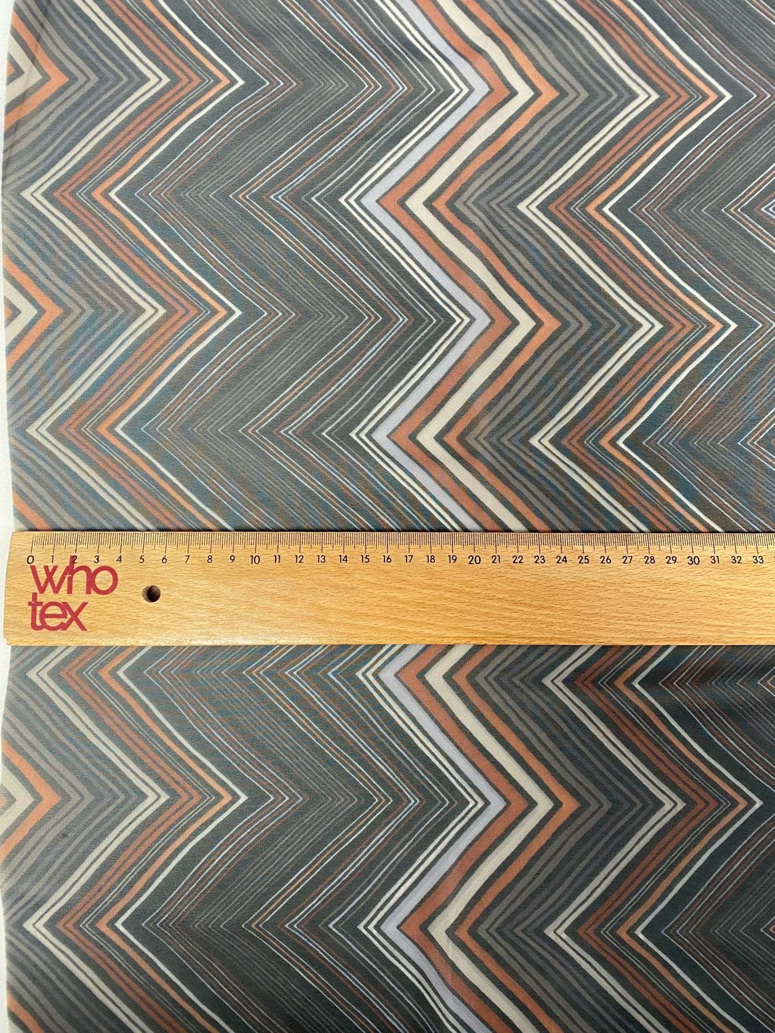 Brown and beige chevron zigzag pattern fabric with ruler for scale, 150cm wide textile for home decor and upholstery projects