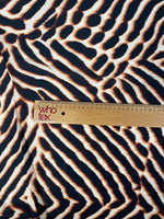 Brown and black animal print fabric with ruler for scale showing bold pattern and texture