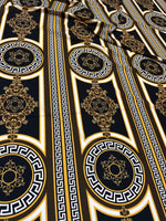 Brown silky crepe fabric with Greek key pattern and ornate circular designs in black, white, and gold tones.