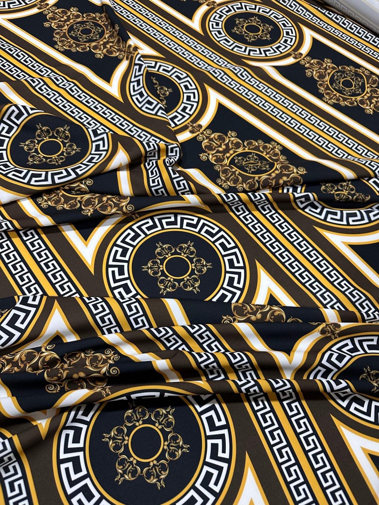 Brown silky crepe fabric with intricate Greek key pattern and gold accents, smooth and elegant texture