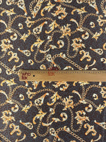 brown leopard print fabric with gold baroque chains and decorative scrolls with ruler for scale