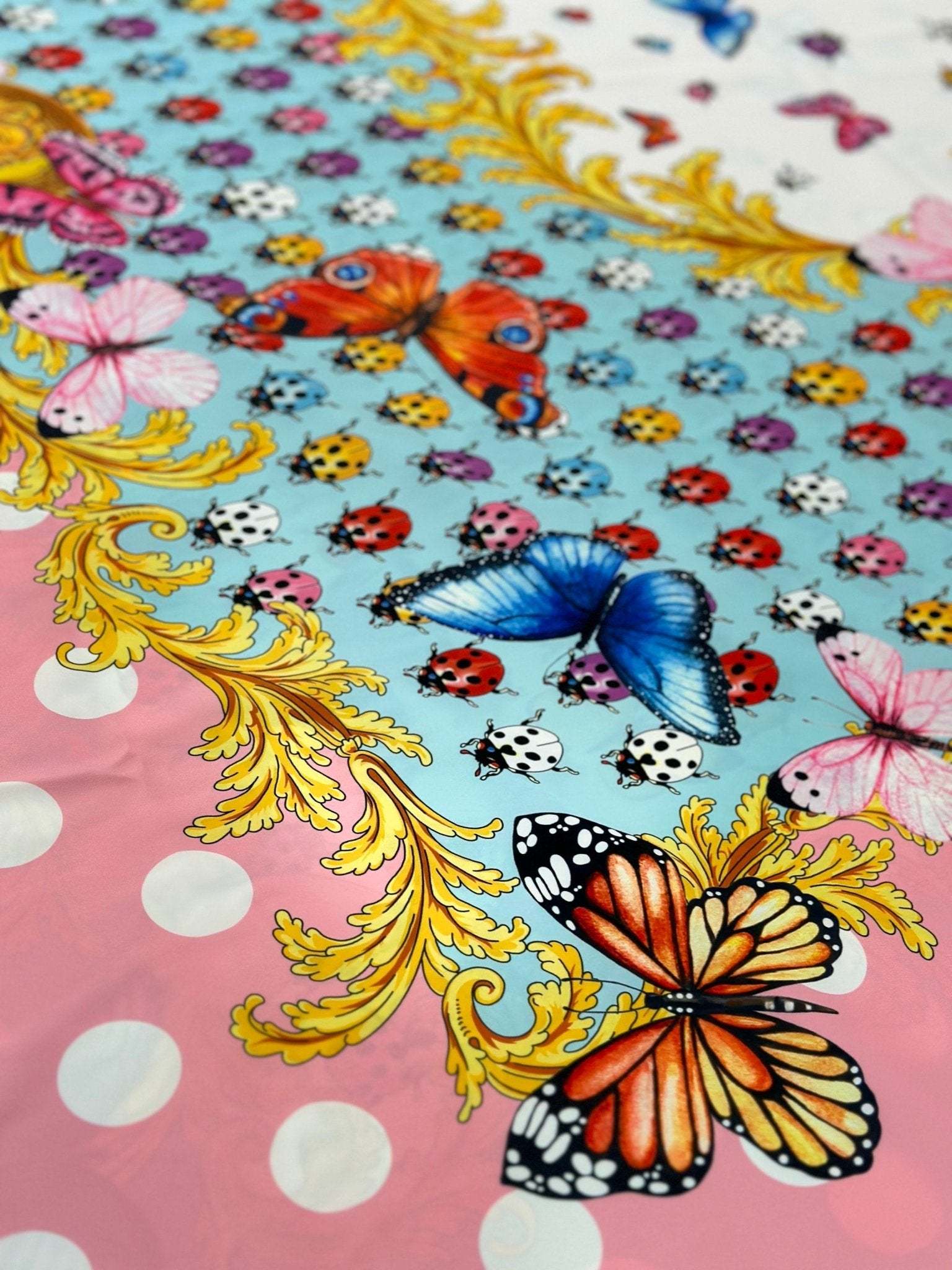 Colorful butterfly and ladybug pattern fabric with polka dot border and ornate yellow detailing