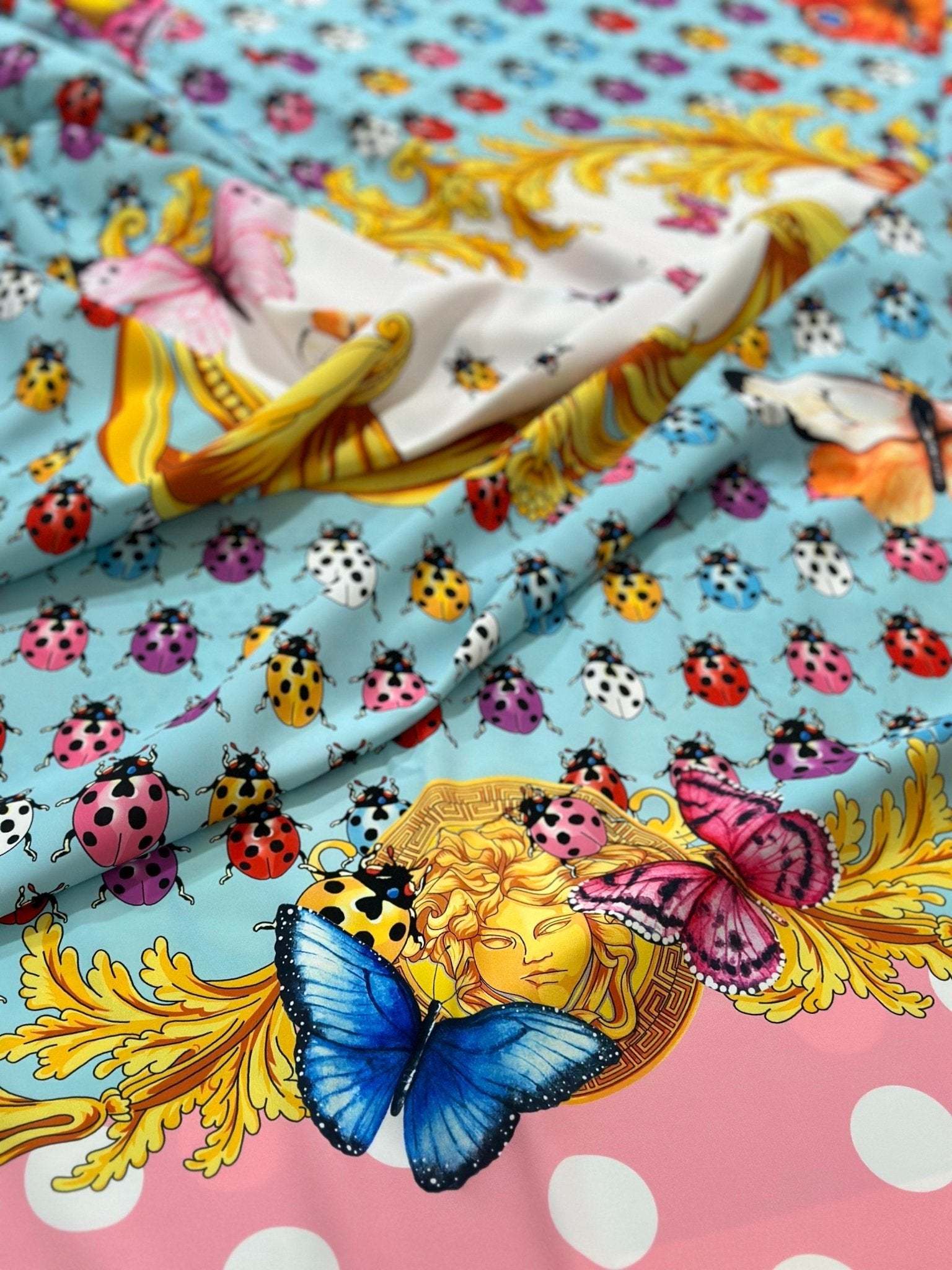 Colorful butterfly and ladybug pattern fabric with polka dot border and vibrant design