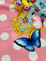 Colorful butterfly and ladybug pattern fabric with polka dot border on pink background