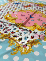 Colorful butterfly and polka dot print fabric with gold ornate detailing on blue background