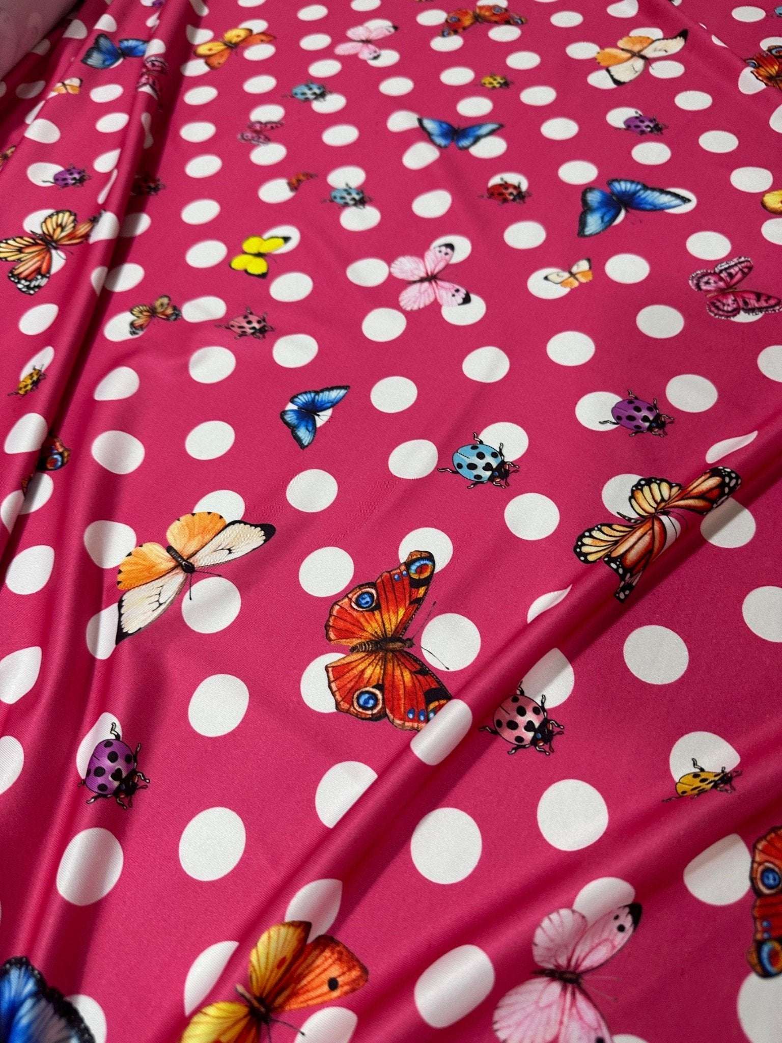 Pink fabric with white polka dots and colorful butterfly print butterfly polka dot fabric