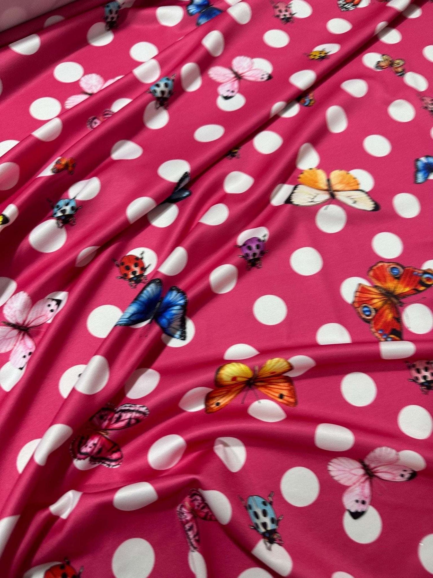 Pink fabric with white polka dots and colorful butterfly and ladybug patterns butterfly polka dot fabric