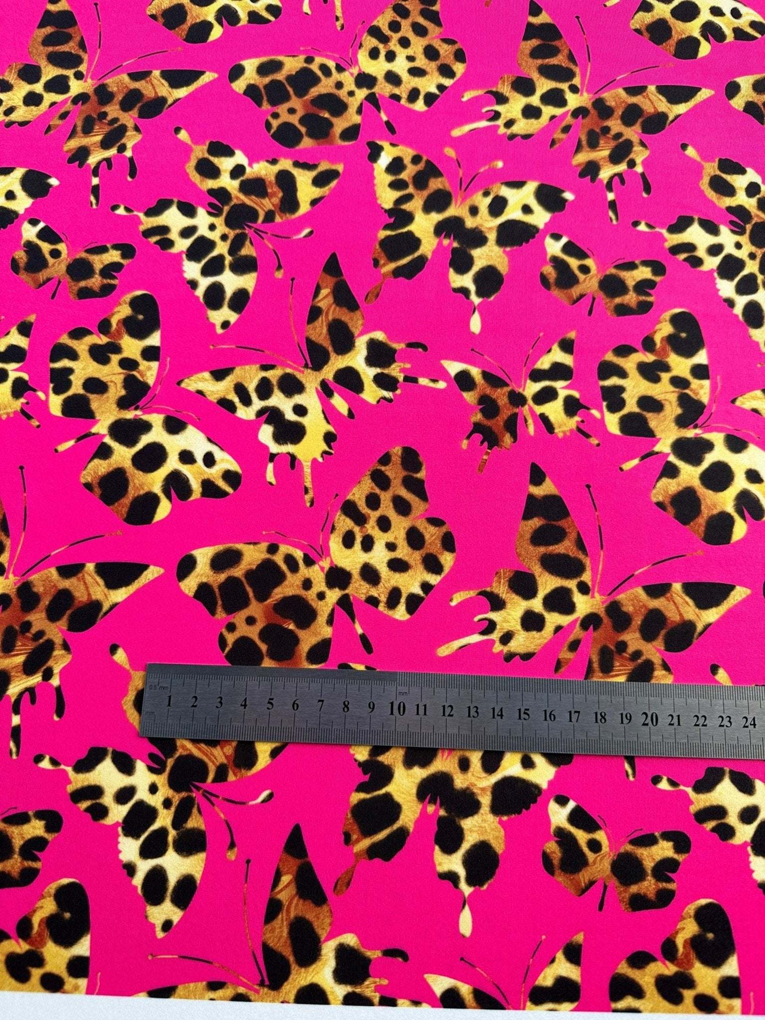 Hot pink fabric with leopard-print butterfly pattern and measuring ruler