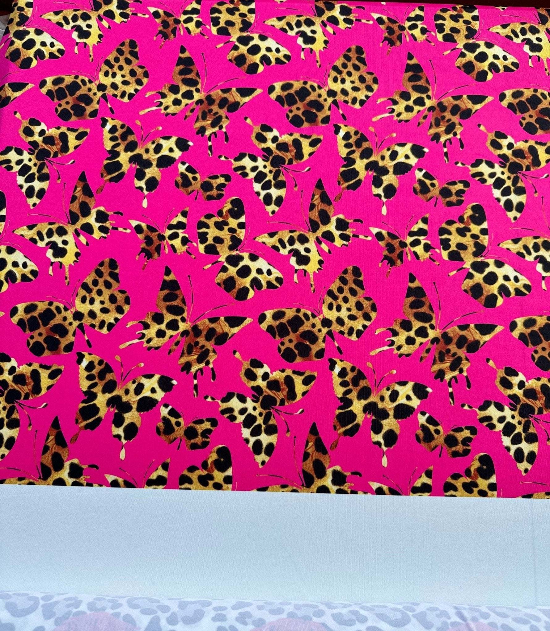 Hot pink fabric with leopard print butterfly pattern for sewing and crafting projects