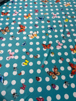 Baby blue fabric with white polka dots and colorful butterfly prints