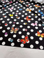 Black fabric with white polka dots and colorful butterfly and ladybug print pattern