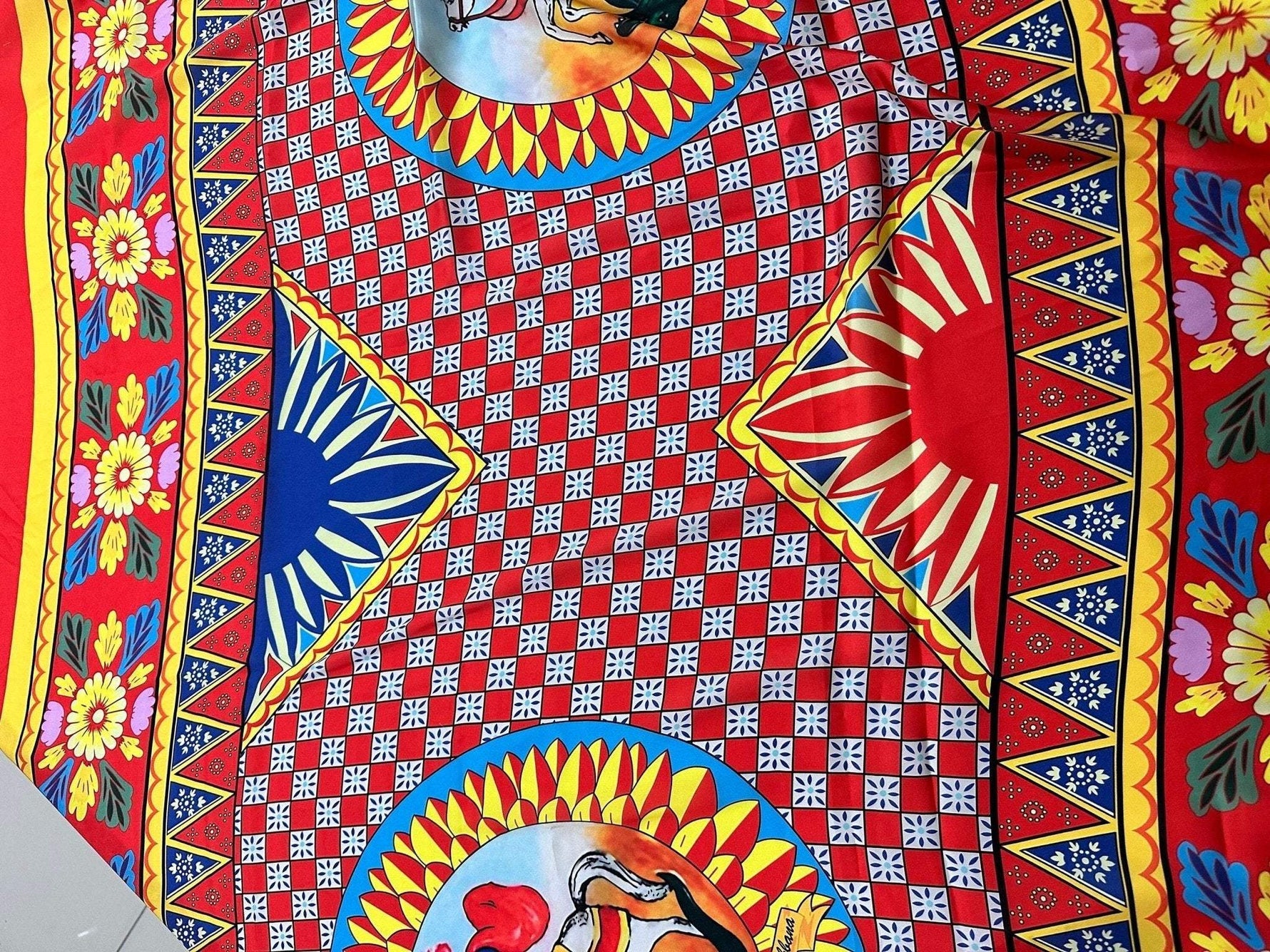 Brightly colored Caretto Scilly design fabric with intricate geometric and floral patterns in red, blue, yellow, and white