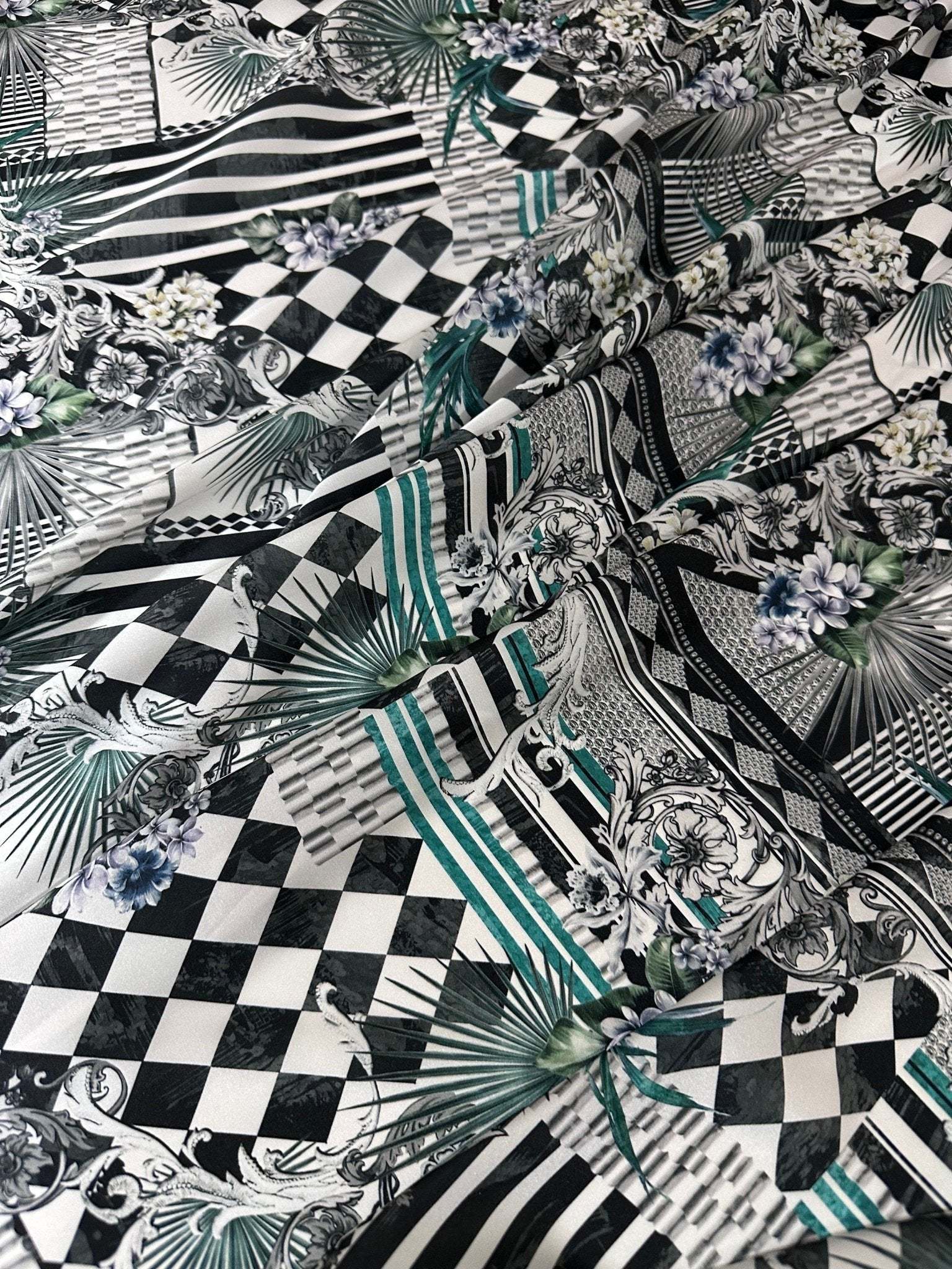 Checkerboard patchwork fabric with black and white squares and floral accents for quilting and crafting projects