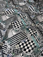 Checkerboard patchwork fabric with black and white geometric patterns and floral accents for quilting and home decor projects