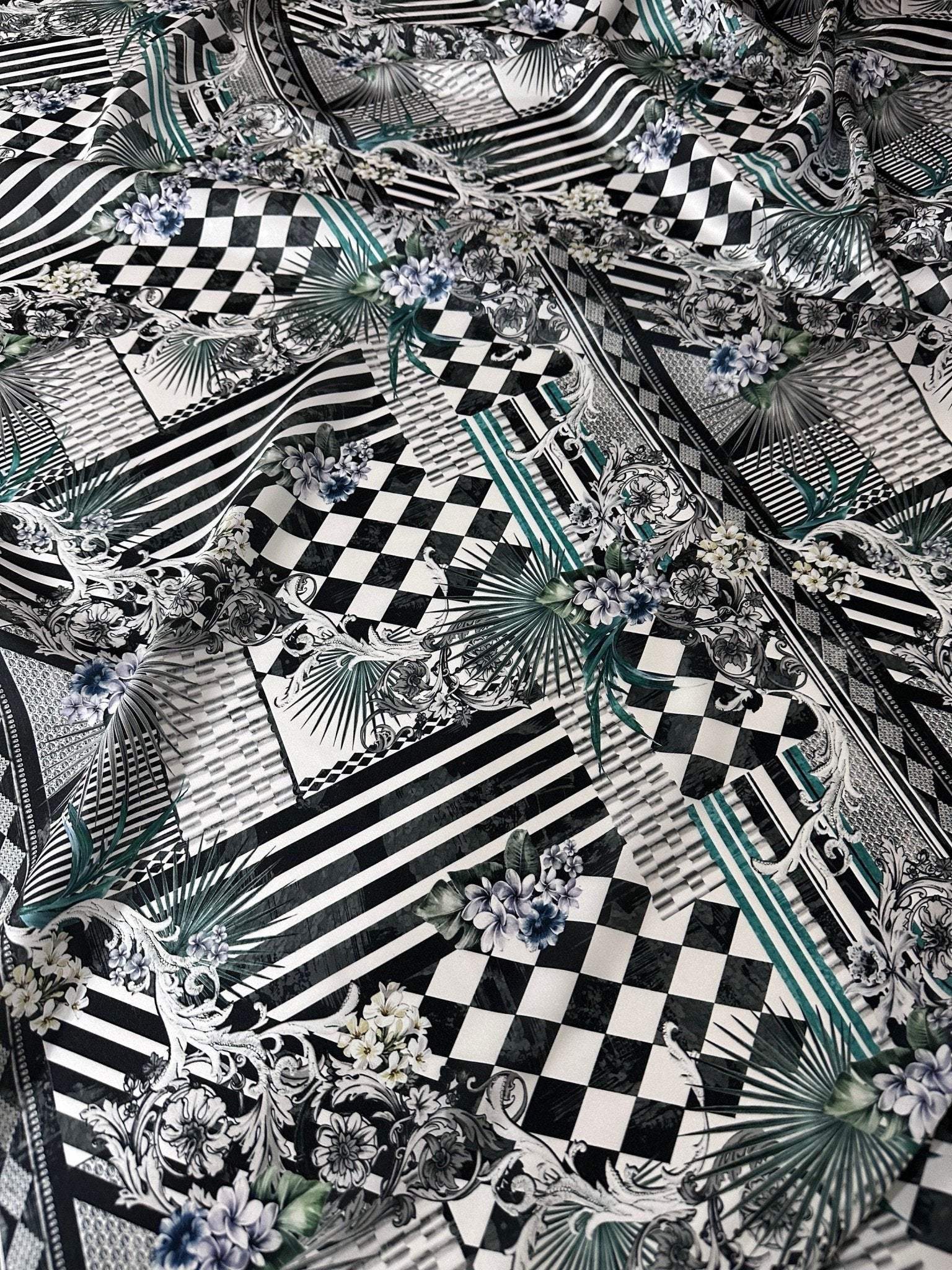 Checkerboard patchwork fabric with black and white geometric patterns and floral accents for quilting and home decor projects