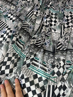 Checkerboard patchwork fabric with black and white geometric and floral patterns in a close-up view