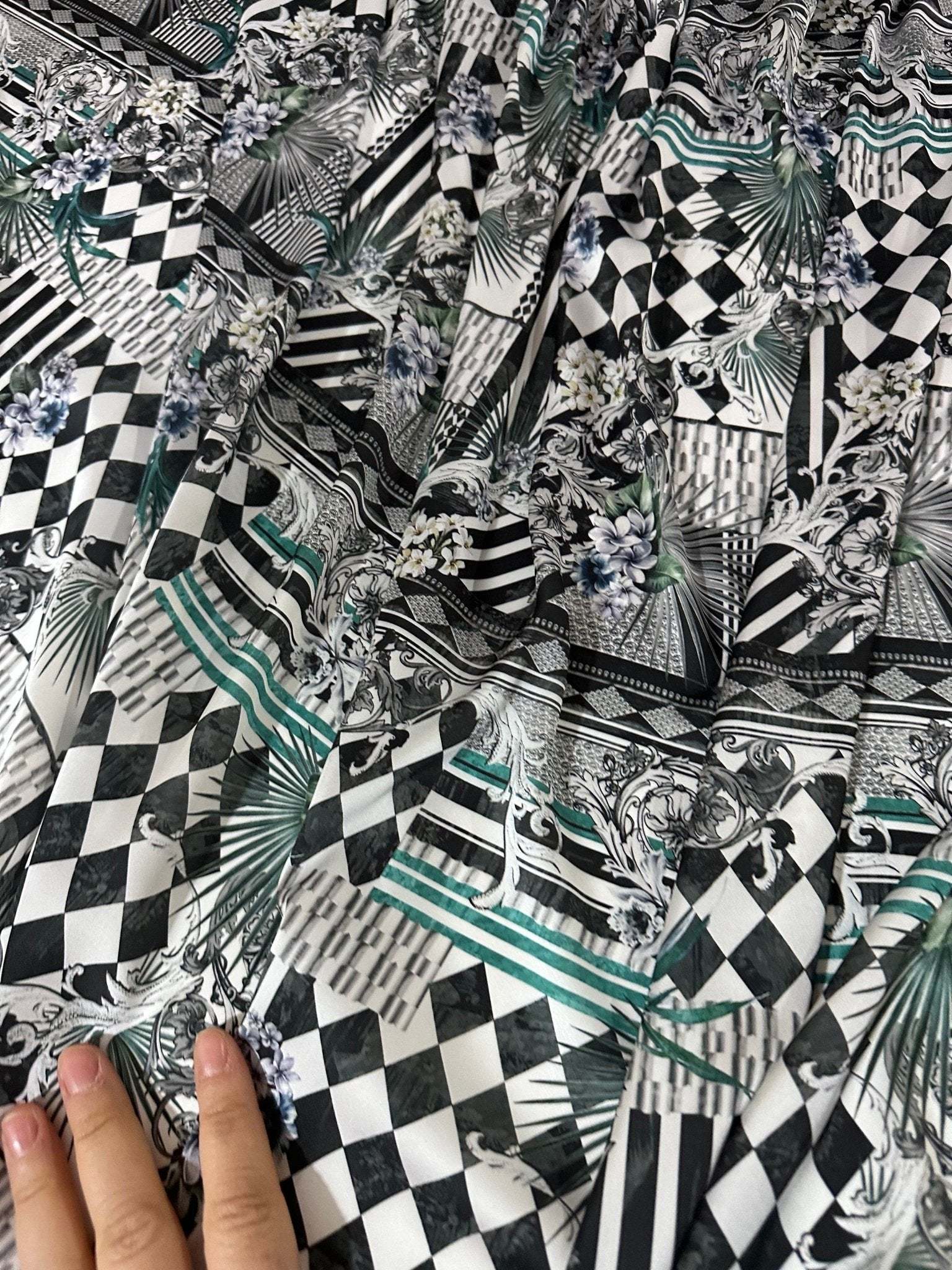 Checkerboard patchwork fabric with black and white geometric and floral patterns in a close-up view