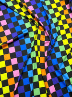 Colorful rainbow checkers print fabric with vibrant squares in multiple colors on black background, ideal for sewing and crafts