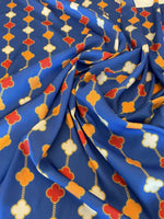Navy blue fabric with orange, red, and white clover chain pattern and gold outlines