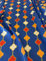 Navy blue fabric with orange, white, and red clover chain pattern