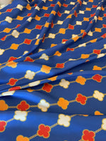 Navy blue fabric with red, white, and orange clover chain pattern, smooth texture, 150cm wide