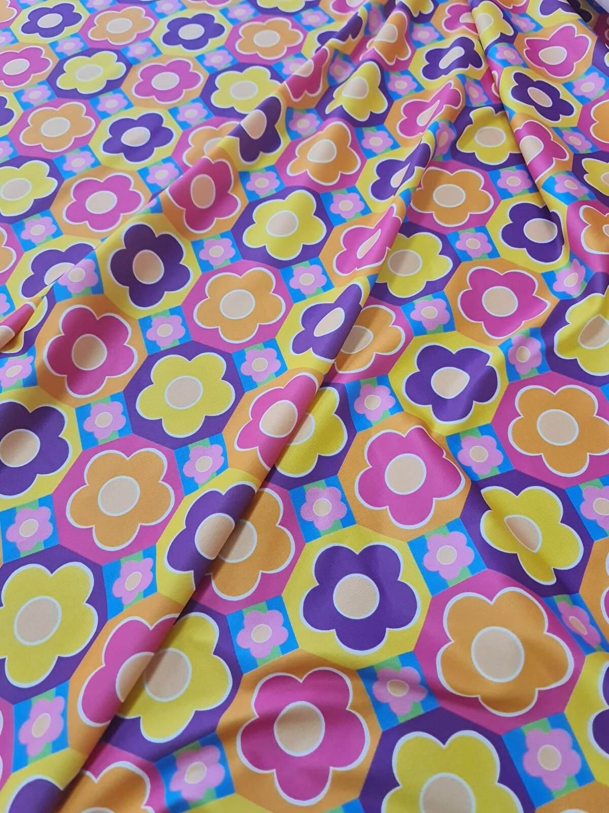 Colorful floral fabric with vibrant flower patterns in pink, yellow, purple, and orange hues, ideal for sewing and crafting projects