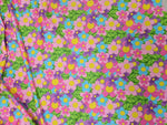 Bright colorful floral fabric with pink, blue, purple flowers and green leaves pattern