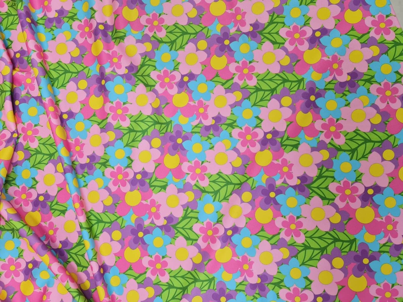 Bright colorful floral fabric with pink, blue, purple flowers and green leaves pattern