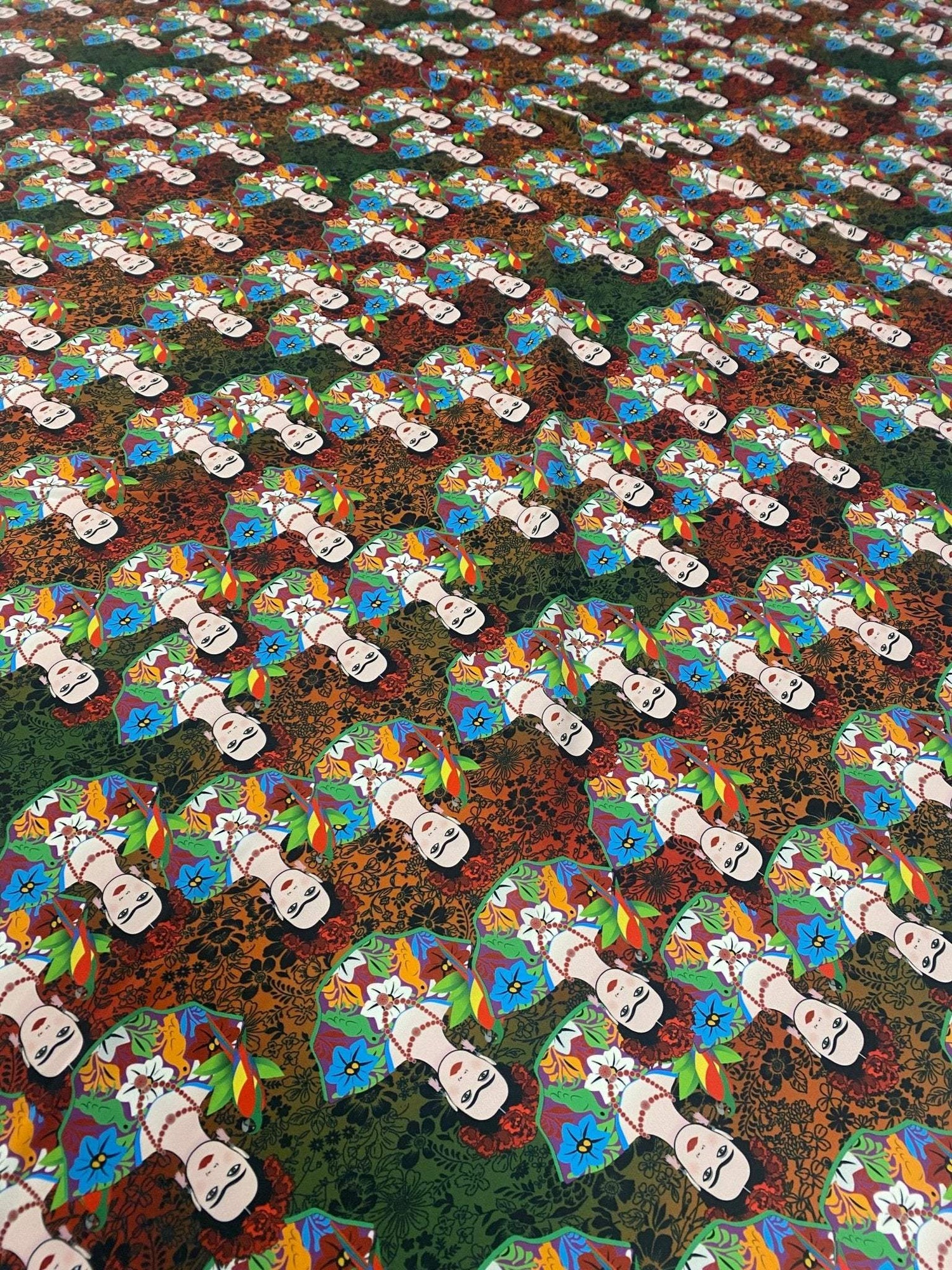 Colorful Frida Kahlo inspired floral print fabric with vibrant flowers and repeated artist portraits on a multicolored background