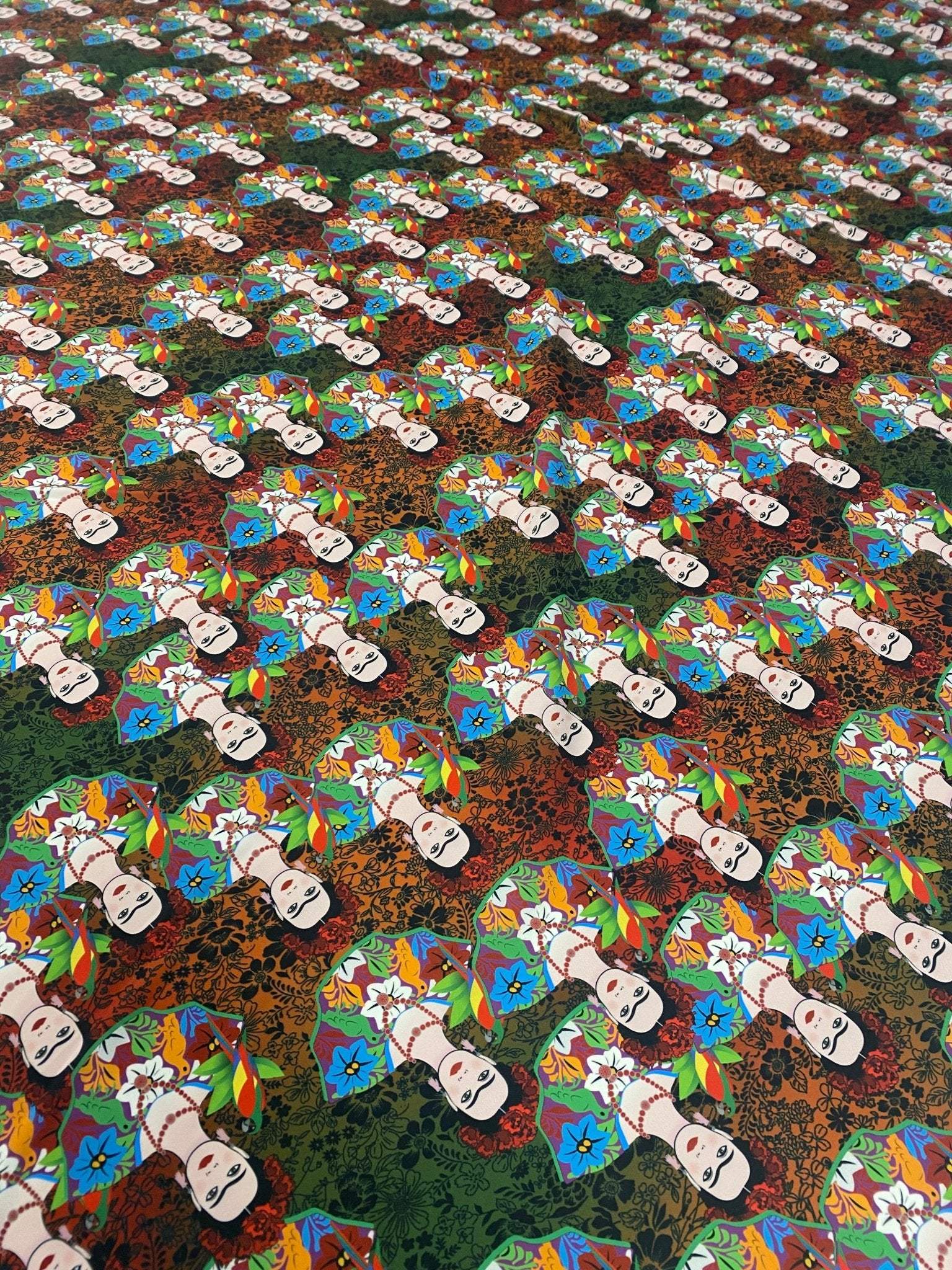 Colorful Frida Kahlo inspired floral print fabric with vibrant flowers and repeated artist portraits on a multicolored background
