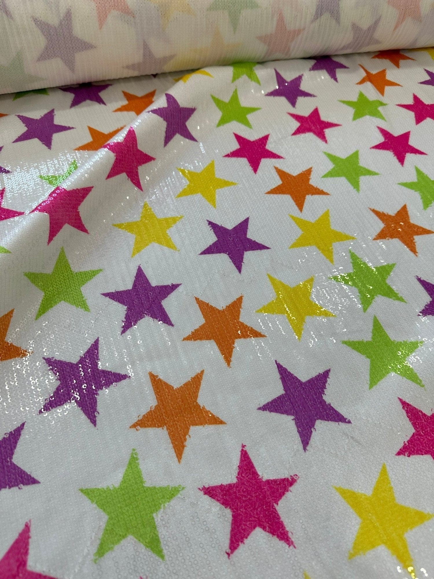 Close-up of colorful stars sequin fabric with 2-way stretch on white background for fashion use