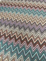 Colorful zigzag upholstery fabric with vibrant chevron pattern in teal, brown, purple, and cream for creative home décor projects