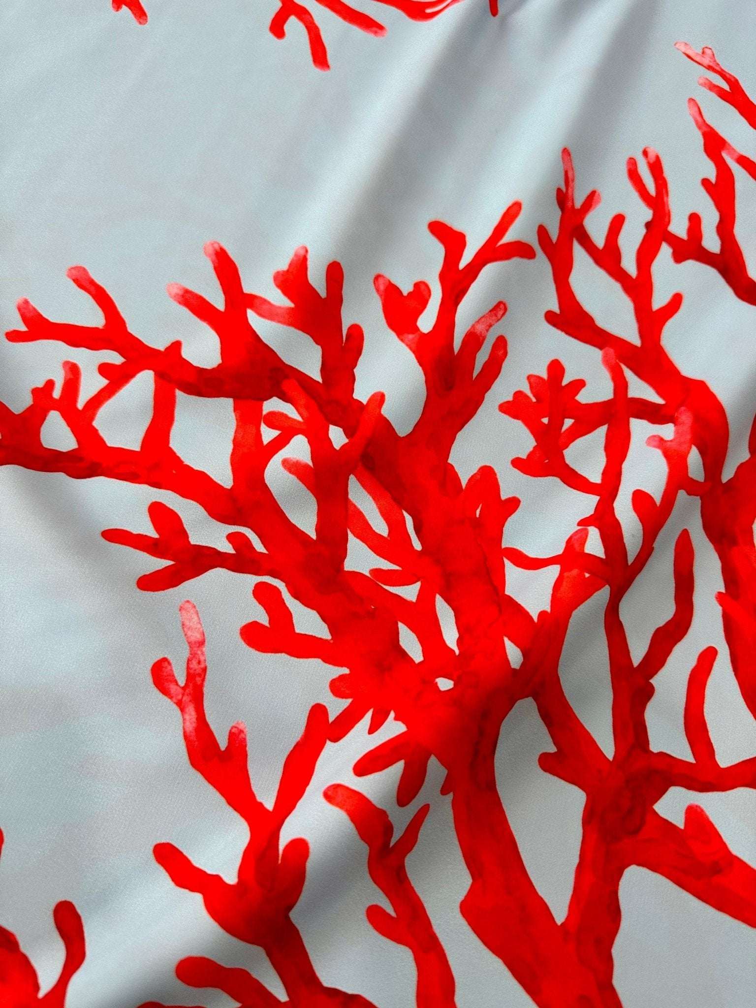 Silky crepe fabric with vibrant red coral pattern on blue background, 150cm width