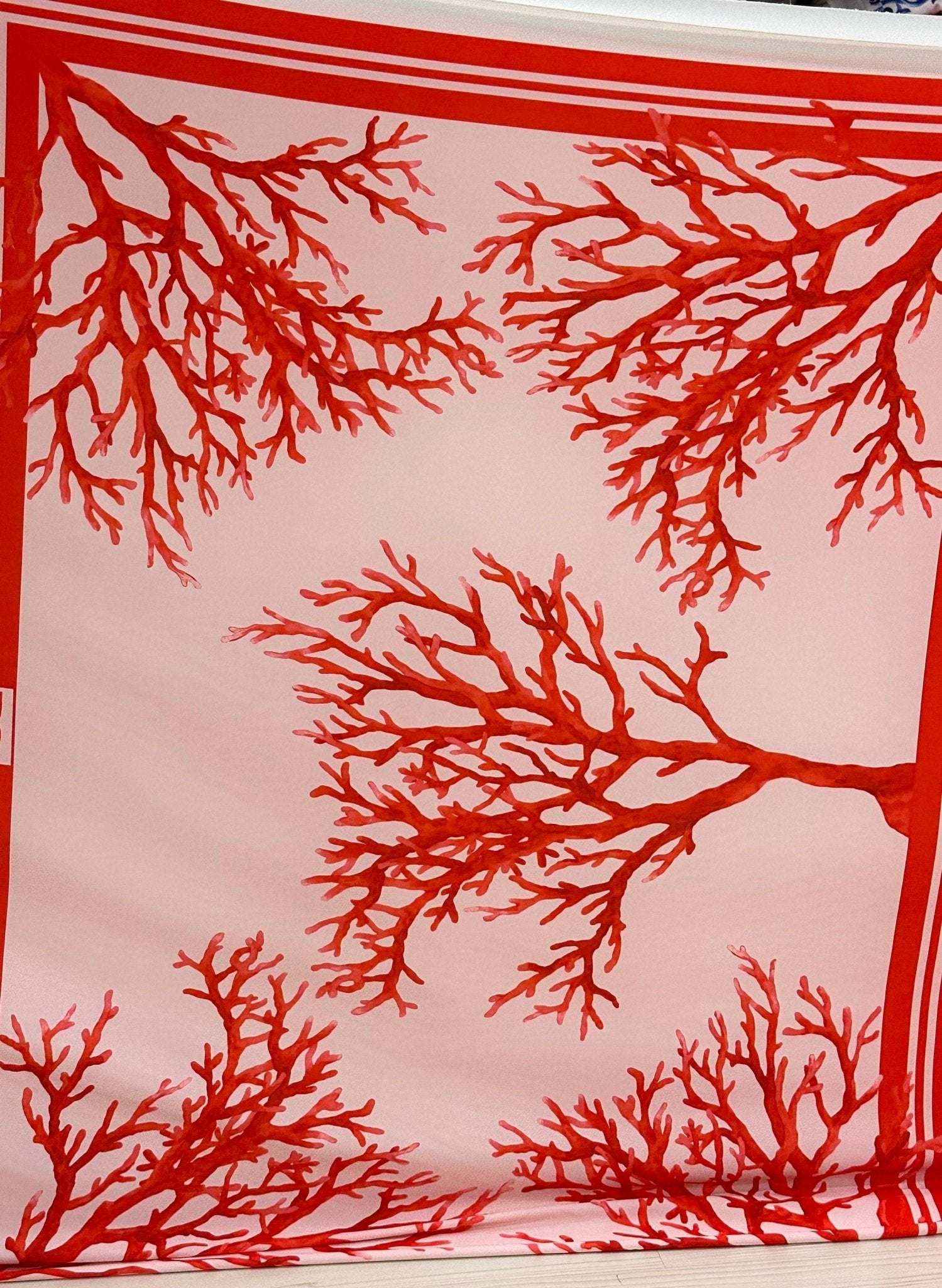 Silky crepe fabric with vibrant red coral pattern on soft pink background, 150cm wide
